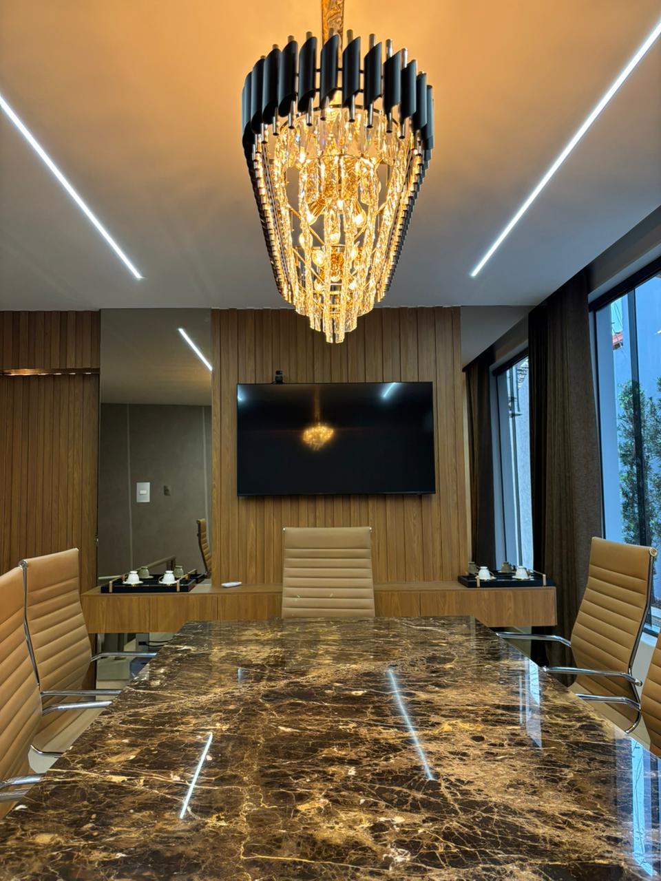 Sala de reunião com mesa de mármore e lustre de cristal
